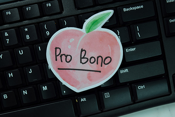 peach cut out with the words "Pro Bono" on top of a keyboard
