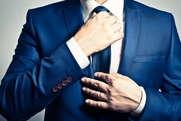 man adjusting his tie