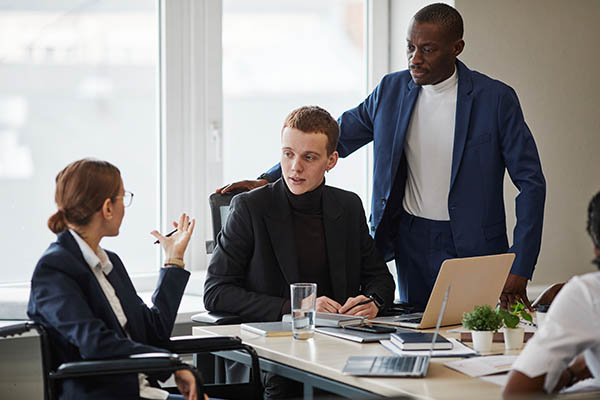 group of people sitting at a table discussing something