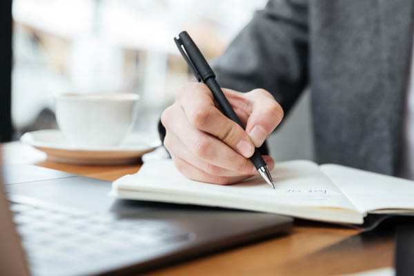 person writing in a notebook