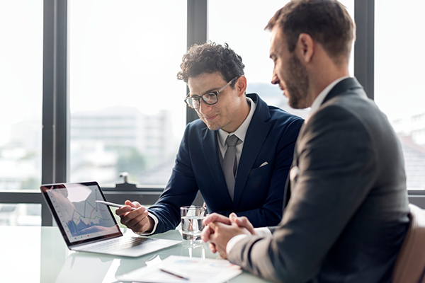 one person showing another person something on a laptop screen