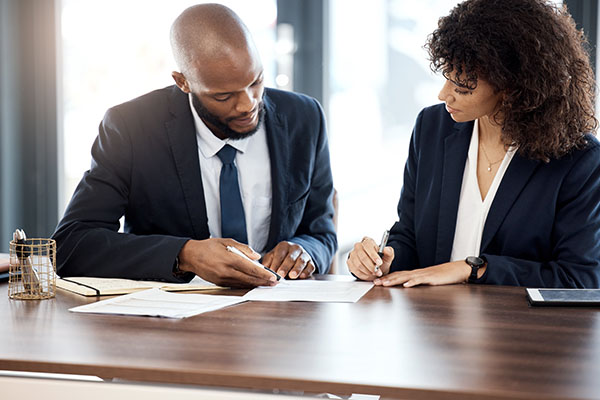 two people discussing over paperwork